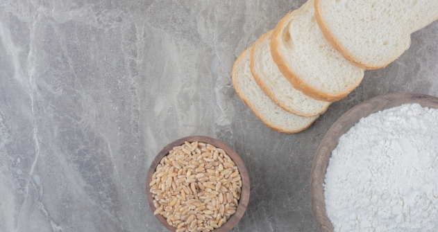 A loaf of white bread with oat grains and flour on marble background A loaf of white bread with oat grains and flour on marble background. High quality photo